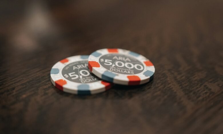 two poker chips sitting on top of a wooden table