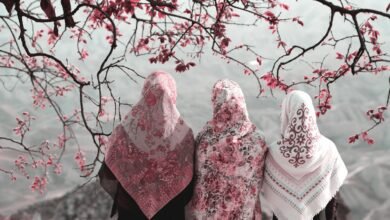 three woman standing near tree