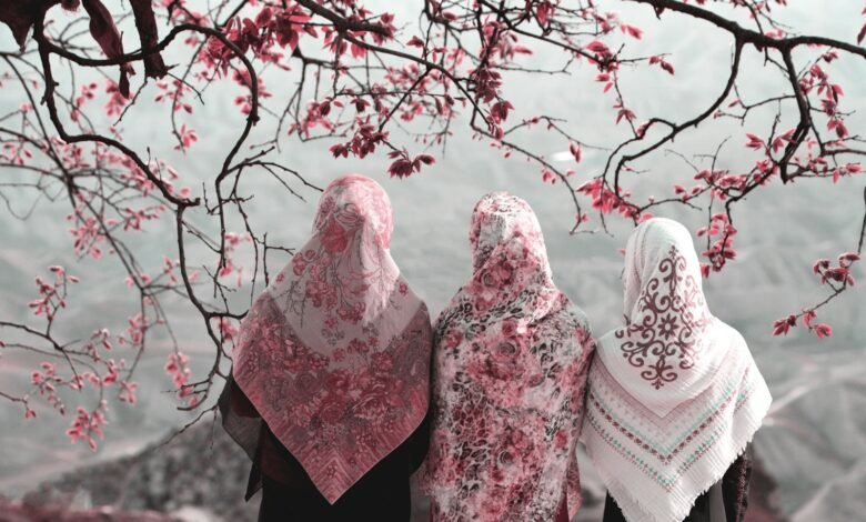 three woman standing near tree